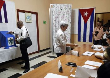 Dos personas votan en las elecciones parlamentarias, en un colegio electoral de La Habana, el domingo 26 de marzo de 2023. Foto: Ernesto Mastrascusa / EFE.