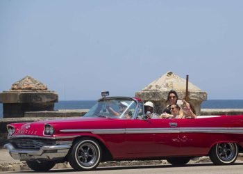 Turistas pasean en un auto clásico por el Malecón de La Habana. Foto: Yander Zamora / EFE.