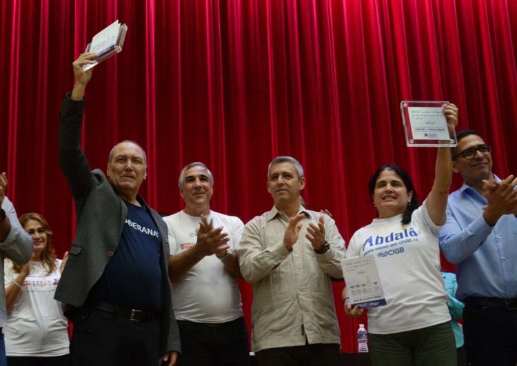 Especialistas del Centro de Ingeniería Genética y Biotecnología y del Instituto Finlay de Vacunas recibieron este sábado el registro sanitario del Centro para el Control Estatal de Medicamentos, Equipos y Dispositivos Médicos (Cecmed) para las vacunas cubanas anti-COVID. Foto: Tomada de la ACN.