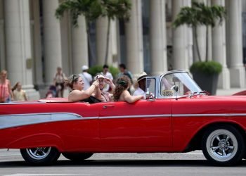 Turistas pasean en un auto clásico en La Habana. Foto: Yander Zamora / EFE.