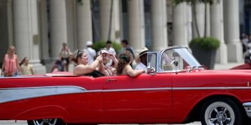 Turistas pasean en un auto clásico en La Habana. Foto: Yander Zamora / EFE.