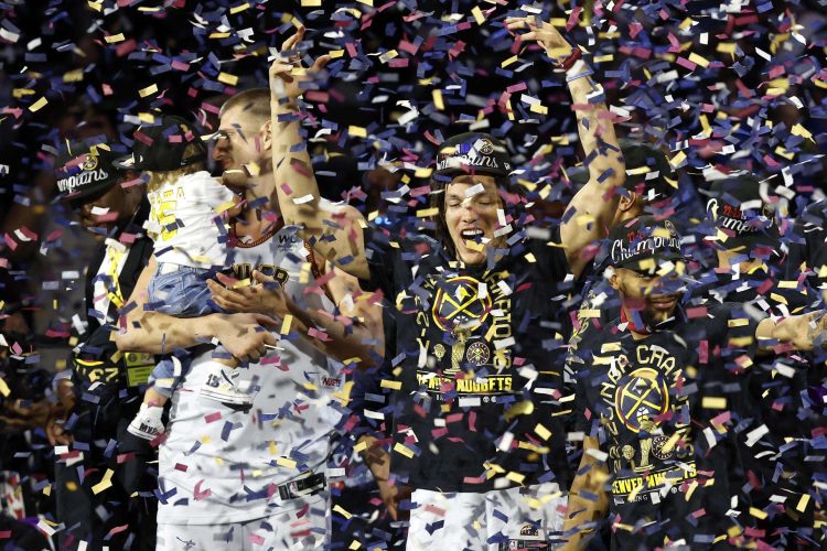 El delantero Aaron Gordon (C), el central del Denver Nuggets Nikola Jokic (I) y su hija Ognjena, y otros miembros del equipo celebran en el podio. Foto: EFE/EPA/John G. Mabanglo.