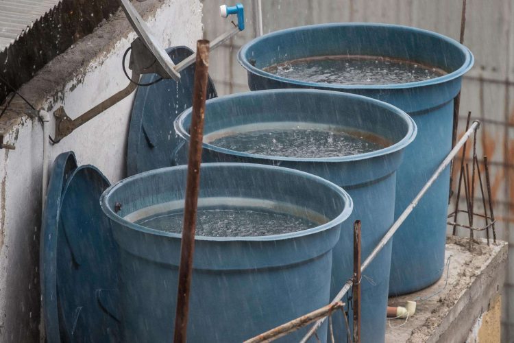 Contenedores llenos de agua por las lluvias de Bret sobre Caracas. Foto: MIGUEL GUTIERREZ/EFE.