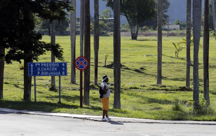 Un hombre espera la llegada de una auto, en Nueva Gerona, la capital del municipio especial Isla de la Juventud, donde se desarrolla el festival Internacional de Cine y Medioambiente Isla Verde. Foto:  Ernesto Mastrascusa/EFE.