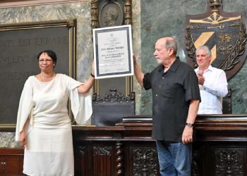 La rectora de la Universidad de La Habana, Miriam Nicado, entre el título de Doctor Honoris Causa al trovador Silvio Rodríguez. Detrás, el presidente cubano Miguel Díaz-Canel. Foto: @PresidenciaCuba / Twitter.