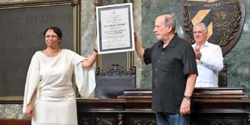 La rectora de la Universidad de La Habana, Miriam Nicado, entre el título de Doctor Honoris Causa al trovador Silvio Rodríguez. Detrás, el presidente cubano Miguel Díaz-Canel. Foto: @PresidenciaCuba / Twitter.