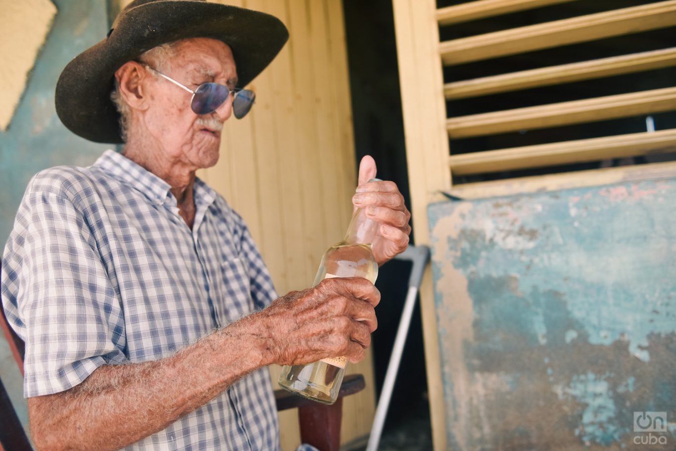 Juanito abre la botella de ron que le regaló su paciente. Foto: Kaloian.
