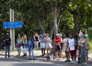 Varias personas esperan una guagua a la sombra, en La Habana. Foto: EFE/ Yander Zamora.