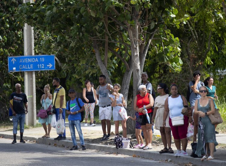 Varias personas esperan una guagua a la sombra, en La Habana. Foto: EFE/ Yander Zamora.