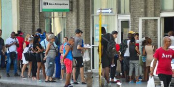 Personas hacen cola para entrar a un banco y para acceder a un cajero automático en La Habana. Foto: Otmaro Rodríguez.