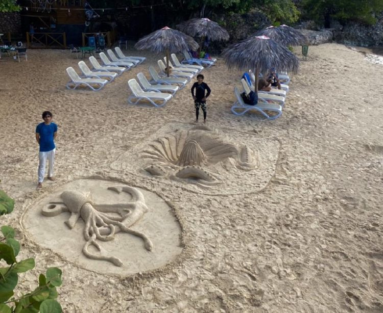 Dos de los participantes junto a las esculturas de arena. Foto: Hotel Club Amigo Atlántico Guardalavaca/Facebook.