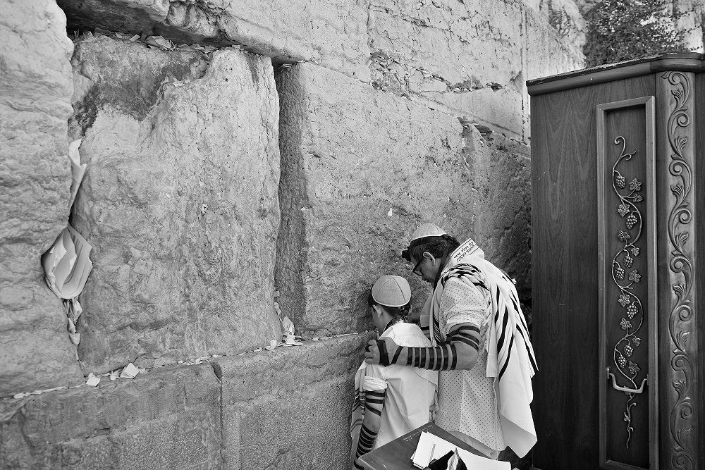 Un padre ora junto a su hijo durante la celebración de su Bar Mitzbah, ceremonia que marca la mayoría de edad religiosa del joven. Foto: Alejandro Ernesto.