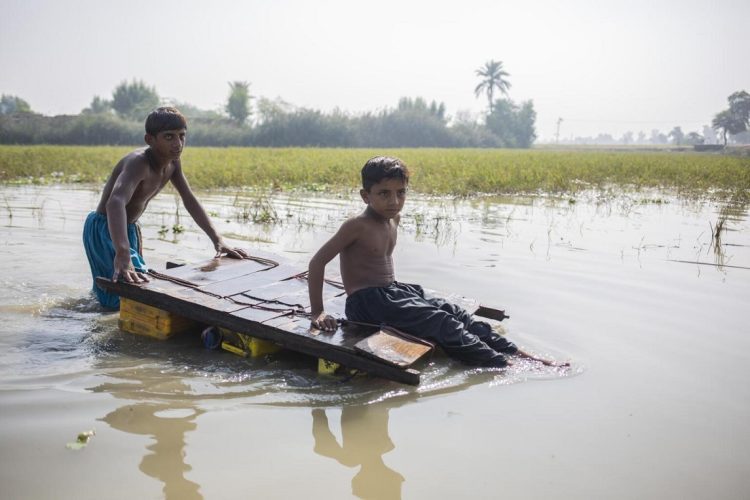 Noviembre de 2022. En Jacobabad, provincia de Sindh, Pakistán, dos niños regresan a casa a través de aguas contaminadas debido a las inundaciones. Foto: UNICFE/Bashir.