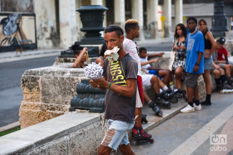 Un grupo de niños y adolescentes, detrás de un vendedor de cucuruchos de maní, en La Habana. Foto: Kaloian Santos Cabrera.