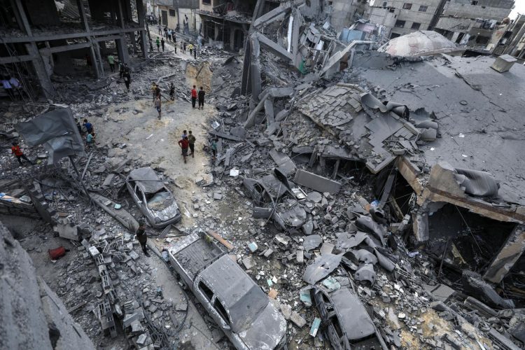 Personas caminan entre los escombros de una zona destruida en Gaza, el 9 de octubre de 2023. Un ataque sin precedentes en el sur de Israel, por Hamas, reactivó el conflicto entre Israel y Palestina. Foto: MOHAMMED SABLE/EFE/EPA.