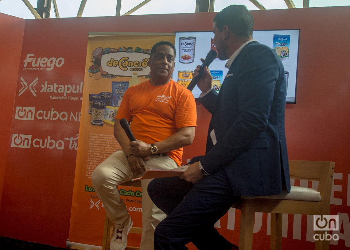 El empresario cubanoamericano Hugo Cancio conversa con el conductor Héctor Villar, durante el lanzamiento mundial de la marca deCancio Foods en la Feria Internacional de La Habana FIHAV 2023. Foto: Otmaro Rodríguez.