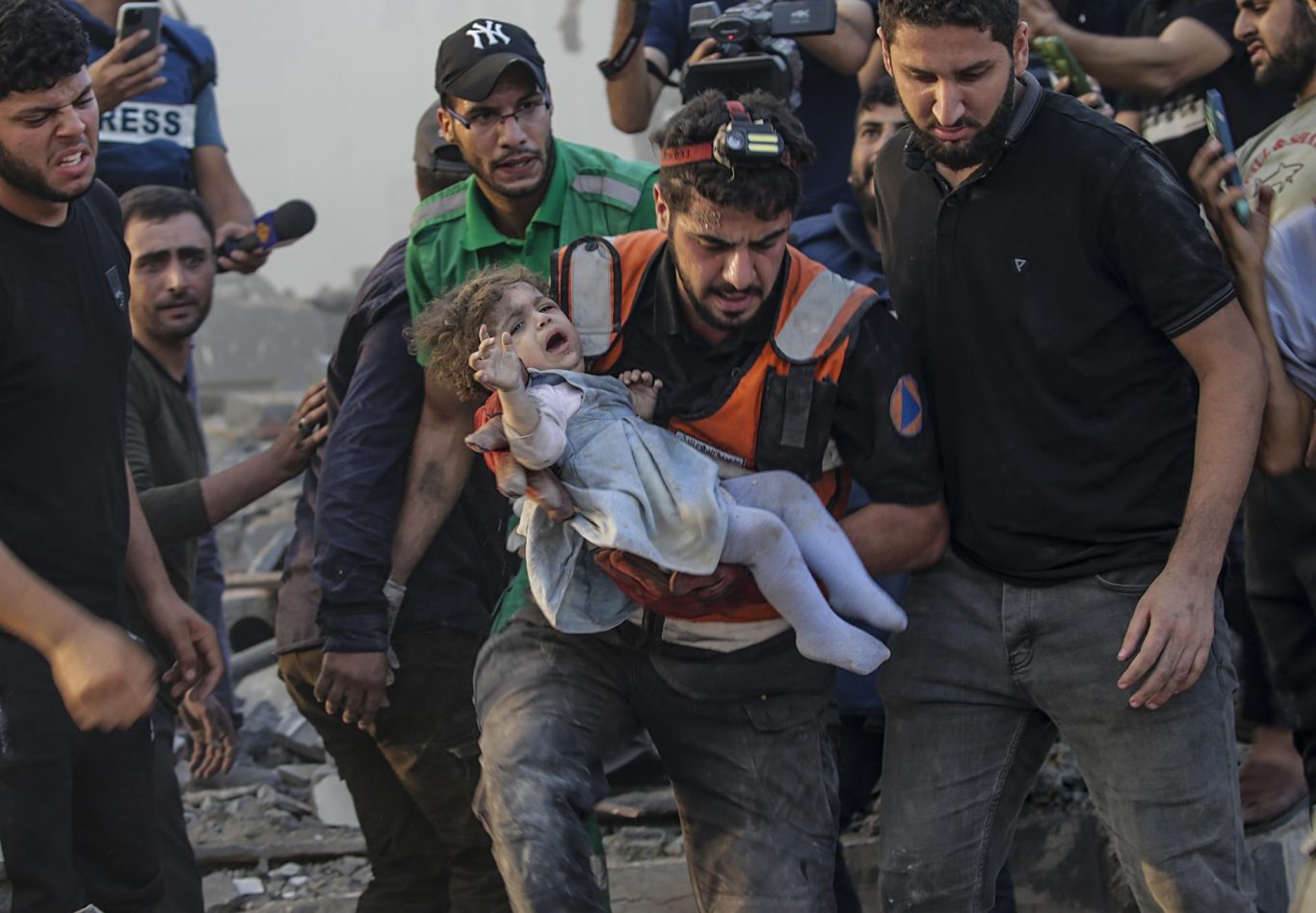 Un palestino carga a una niña herida recién recuperada de los escombros de un área destruida por un ataque aéreo israelí en Gaza, 25 de octubre de 2023. Foto: EFE/EPA/Mohammed Saber. 