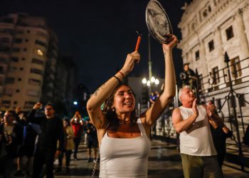 Mujer golpea una cacerola durante una manifestación contra las medidas anunciadas el miércoles por el presidente Javier Milei, frente al Congreso de la Nación. Foto: Juan Ignacio Roncoroni/EFE.