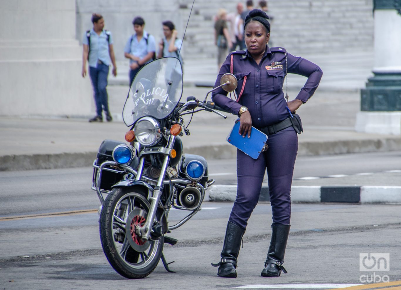 Una oficial de la policía motorizada controlando el tránsito en una calle de La Habana. Foto: Kaloian.
