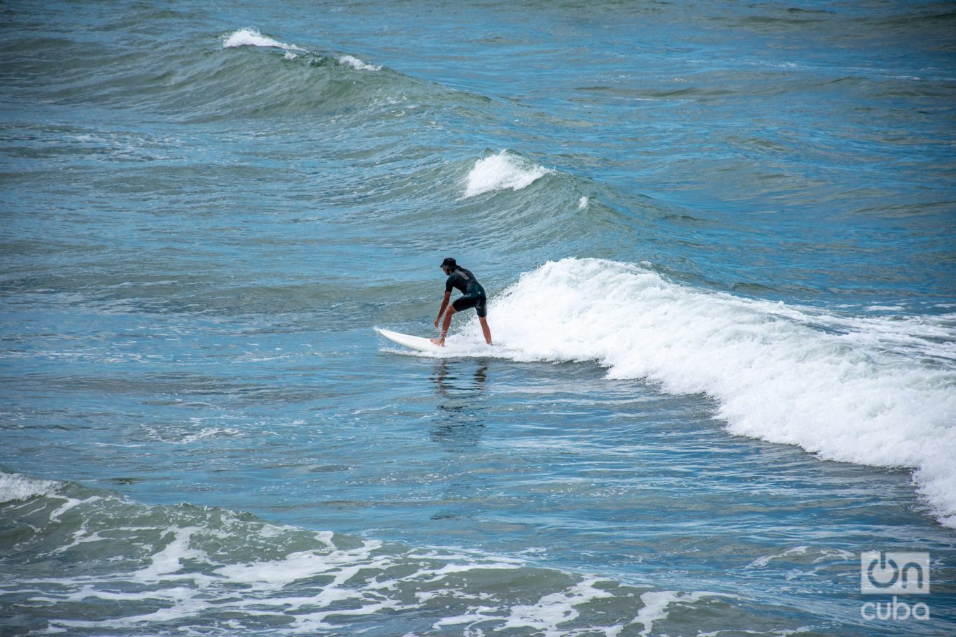 Un surfista en una playa de Mar del Plata logra el objetivo de remontar una ola. Foto: Kaloian.