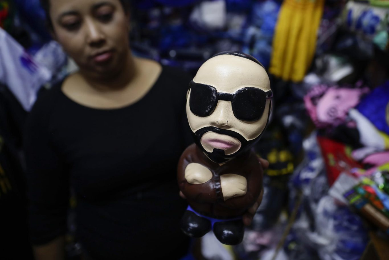 Una mujer muestra una alcancía alusiva al presidente Nayib Bukele, en el centro de San Salvador. Foto: EFE/Rodrigo Sura.