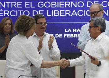 Pablo Beltrán (d), jefe negociador del Ejército de Liberación Nacional (ELN), y Vera Grabe (i), jefa del equipo de negociación del Gobierno de Colombia, se saludan al cierre del sexto ciclo de negociaciones de paz entre ambas partes, celebrado en La Habana. Detrás, y Bruno Rodríguez (c), ministro de Relaciones Exteriores de Cuba. Foto: Ernesto Mastrascusa / EFE.