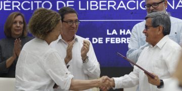 Pablo Beltrán (d), jefe negociador del Ejército de Liberación Nacional (ELN), y Vera Grabe (i), jefa del equipo de negociación del Gobierno de Colombia, se saludan al cierre del sexto ciclo de negociaciones de paz entre ambas partes, celebrado en La Habana. Detrás, y Bruno Rodríguez (c), ministro de Relaciones Exteriores de Cuba. Foto: Ernesto Mastrascusa / EFE.