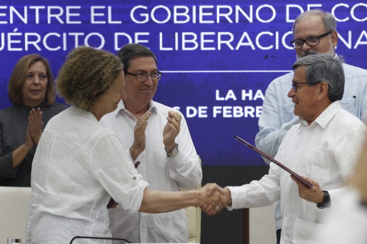 Pablo Beltrán (d), jefe negociador del Ejército de Liberación Nacional (ELN), y Vera Grabe (i), jefa del equipo de negociación del Gobierno de Colombia, se saludan al cierre del sexto ciclo de negociaciones de paz entre ambas partes, celebrado en La Habana. Detrás, y Bruno Rodríguez (c), ministro de Relaciones Exteriores de Cuba. Foto: Ernesto Mastrascusa / EFE.