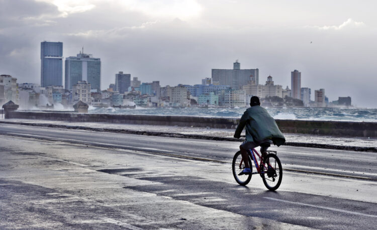 Un hombre pasa en bicicleta por una zona del Malecón el lunes 4 de marzo de 2024, en La Habana. Foto: Ernesto Mastrascusa/EFE.