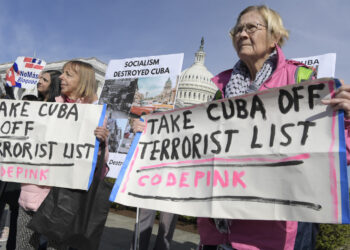 La activista Medea Benjamín (i), del grupo Code Pink, y otra miembro de esa organización, sostienen unas pancartas contra la inclusión de Cuba en la lista de países patrocinadores del terrorismo, mientras interrumpen a la congresista republicana por Florida, María Elvira Salazar, durante una rueda de prensa celebrada este viernes frente al Congreso en Washington. Foto: Lenin Nolly / EFE.