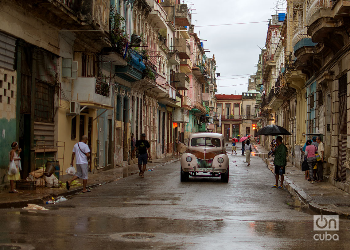 Personas transitan por una calle de La Habana en un día de lluvia. Foto: Otmaro Rodríguez.