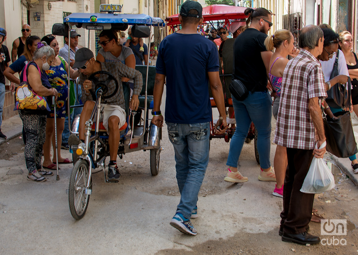 Personas y bicitaxis en una calle de La Habana. Foto: Otmaro Rodríguez.