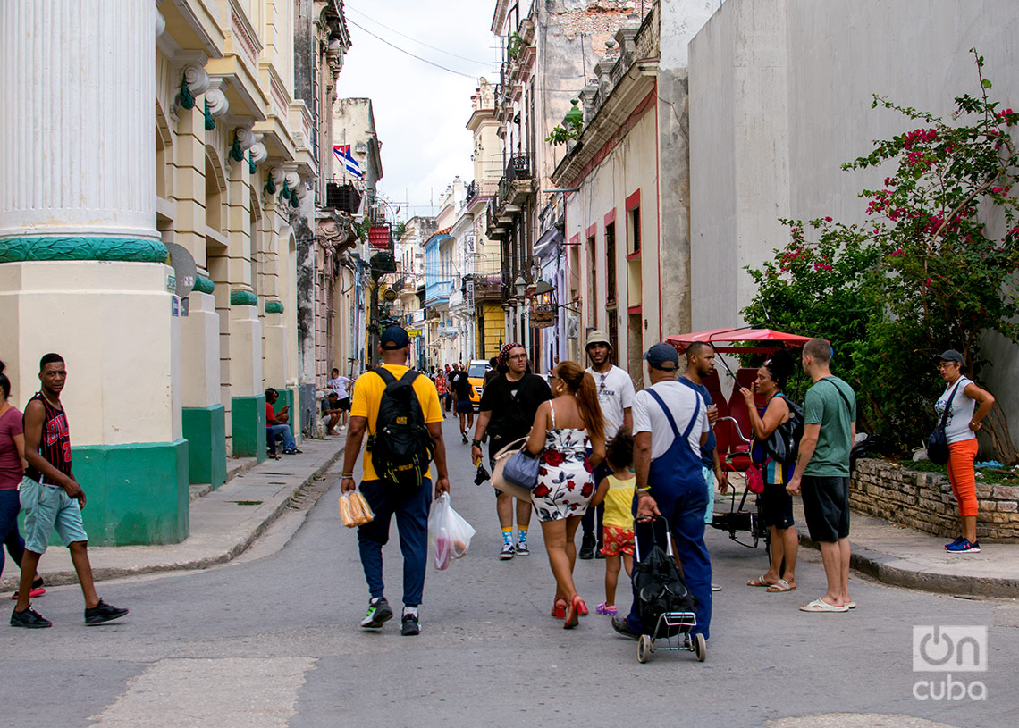 Personas, incluida una familia, por el medio de la calle en La Habana. Foto: Otmaro Rodríguez.