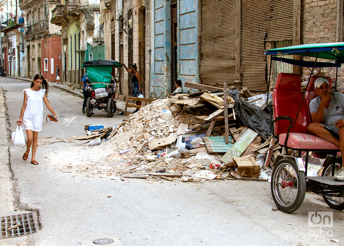 Una mujer sortea una acumulación de  escombros y basura en una calle de La Habana. Foto: Otmaro Rodríguez.
