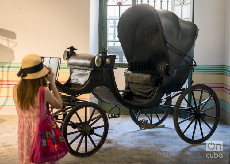 Una visitante fotografía un coche antiguo en el Museo de la Ciudad, en La Habana. Foto: Otmaro Rodríguez.