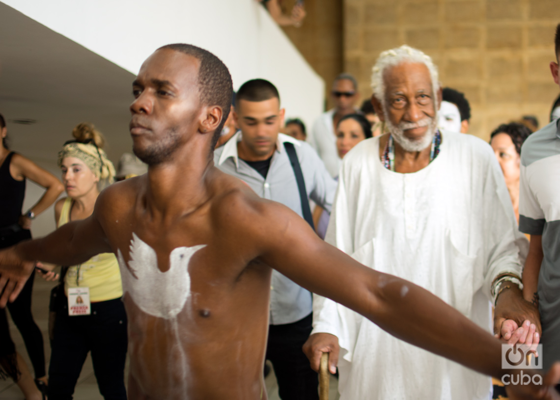 El maestro Manuel Mendive (detrás) en la inauguración de su muestra "Pan con guayaba, una vida feliz", en el Museo Nacional de de Bellas Artes, en La Habana. Foto: Otmaro Rodríguez.