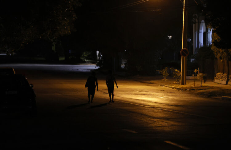 Personas caminan por una calle con poca iluminación en La Habana. Foto: Ernesto Mastrascusa / EFE.