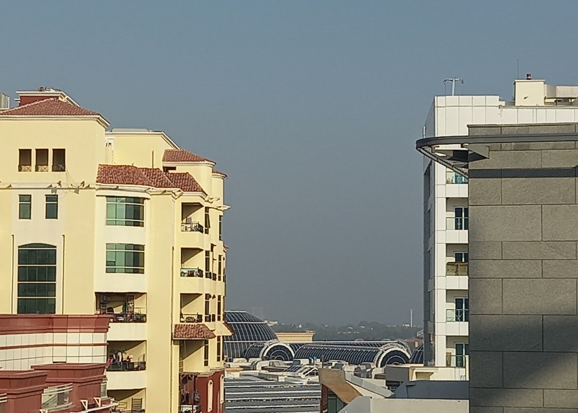 Vista desde el balcón de mi cuarto en Dubái. En espacio gris entre los dos edificios, sobre el techo del Mall of the Emirates, debe verse el mar, pero muchos días no se ve. Foto: Eric Caraballoso Díaz.