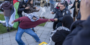 Un estudiante se resiste a un miembro de la policía en una protesta universitaria propalestina en la Ciudad Universitaria de Nueva York. Foto: Ángel Colmenares / EFE.