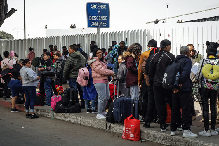 Migrantes esperan sobre una calle en la ciudad de Tijuana, Baja California (México). Foto: Joebeth Terríquez/EFE.