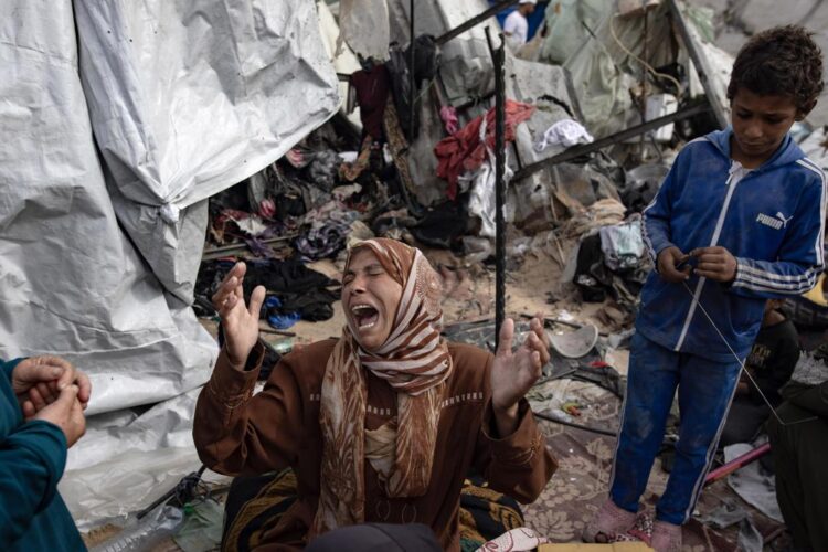 Una mujer en tiendas bombardeadas por Israel en un área designada para desplazados, en Rafah, Gaza. Foto: Haitham Imad / EFE.