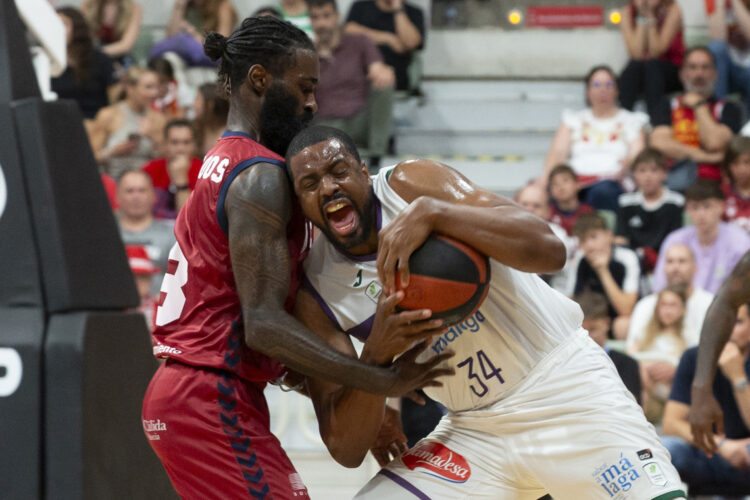 El ala pívot georginao de Unicaja Málaga Will Thomas (d) lucha por el balón ante el alero cubano de UCAM Murcia Howard Sant-Roos (i), durante el cuarto partido de semifinales de la Liga Endesa. Foto: Marcial Guillén/EFE.