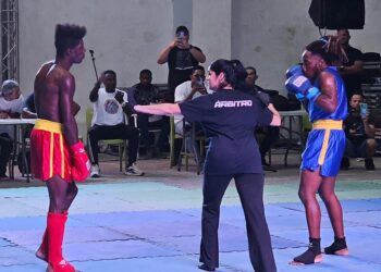 Combate en la modalidad de Sanda, entre el joven trans Ely Malik, de azul, y su rival, en el estadio Martí, en La Habana. Foto: Perfil de Facebook de Claudio Peláez Sordo.