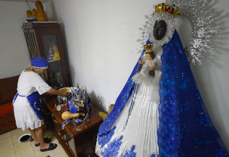 Un creyente cubana enciende incienso en el altar dedicado a la Virgen de Regla, el 6 de junio del 2024, en La Habana. Foto: Yander Zamora / EFE.