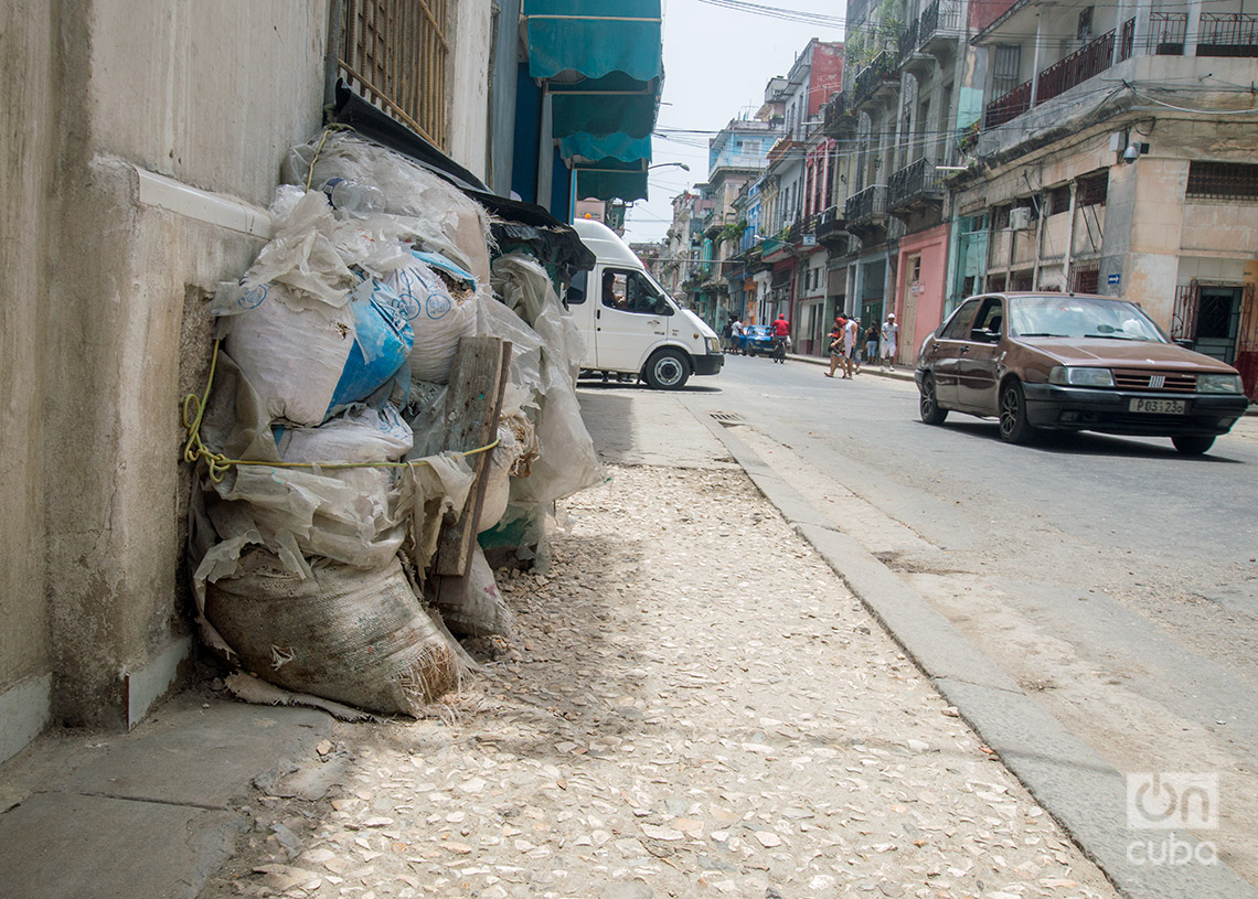 Materiales de construcción acumulados en una acera de La Habana en mal estado. Foto: Otmaro Rodríguez.