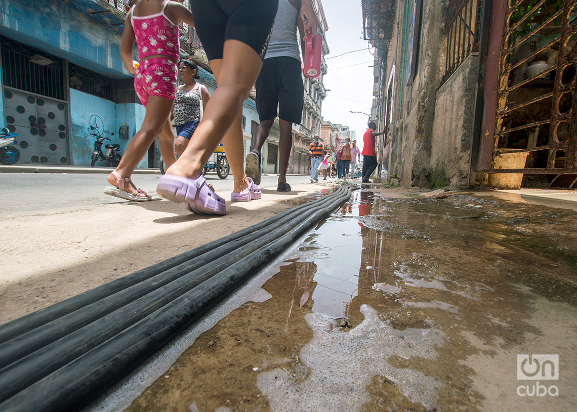 Las personas limpian y lanzan agua hacia las aceras rotas donde hay cables eléctricos. Foto: Otmaro Rodríguez.