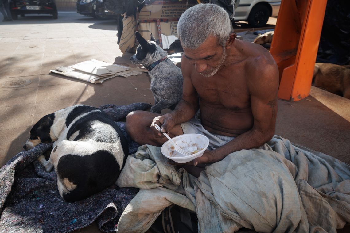 Un hombre come en una calle, en el centro de la ciudad, de Sao Paulo, Brasil.  Foto: Isaac Fontana / EFE.