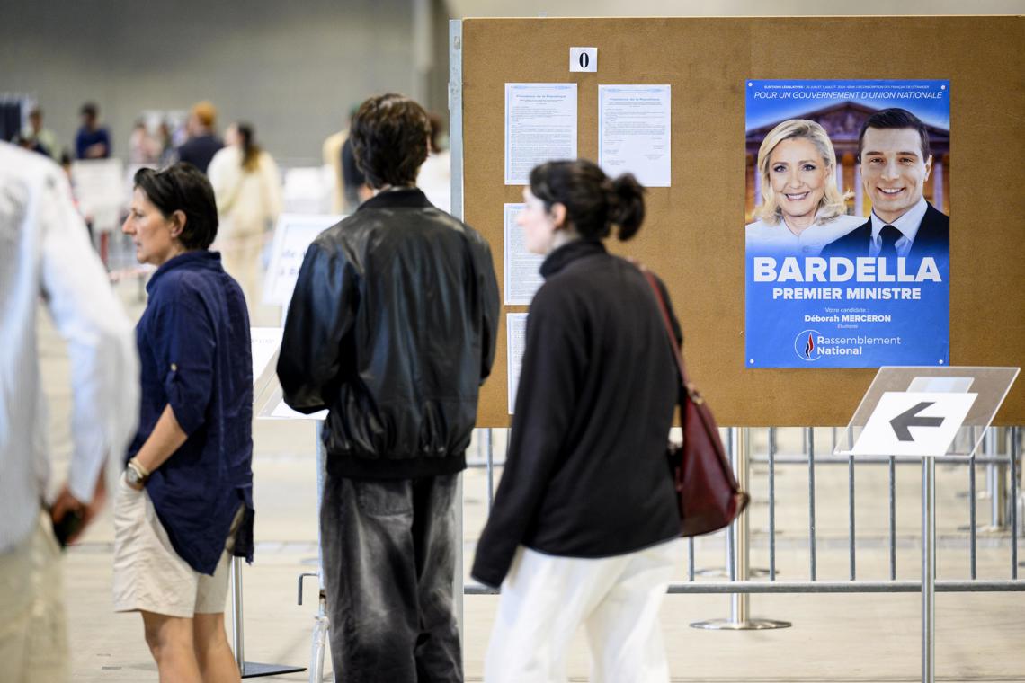 Ciudadanos franceses residentes en Suiza votan en las elecciones parlamentarias de Francia, el domingo 30 de junio de 2024. En un mural, un cartel promocional de Marine Le Pen y Jordan Bardella, del partido de ultraderecha Agrupación Nacional. Foto: Laurent Gillieron / EFE.