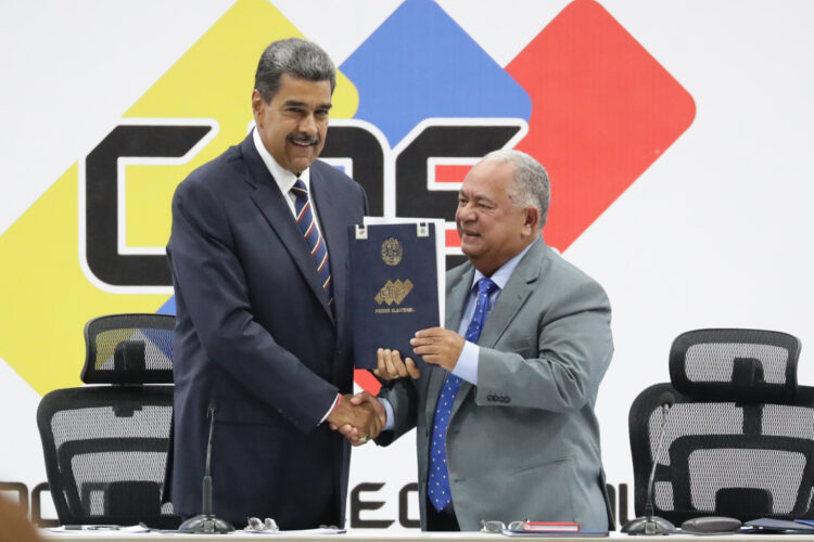 El presidente de Venezuela, Nicolás Maduro (i), y el presidente de Consejo Nacional Electoral (CNE), Elvis Amoroso, sostienen el acta de juramentación del presidente electo, en Caracas, el 29 de julio de 2024. Foto: Ronald Peña R. / EFE.