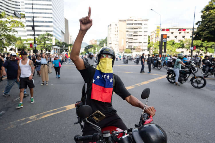 Un hombre en motocicleta participa en una protesta en Caracas por los resultados oficiales de las elecciones presidenciales en Venezuela, el 29 de julio. Foto: Ronald Peña / EFE.